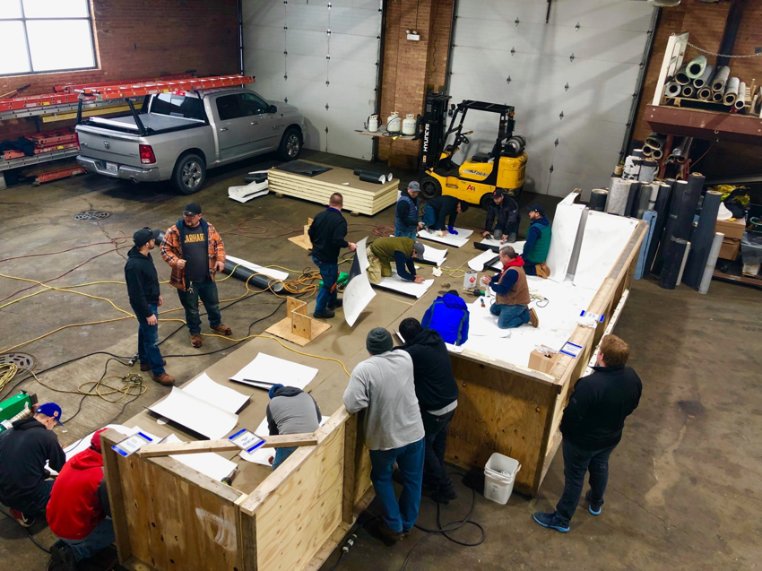 Workers preparing construction materials in a workshop for Active Roofing Company in Chicago, IL