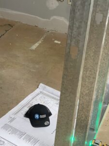 Construction plans and a Ricos Renovations hat on a job site floor in Arlington, TX