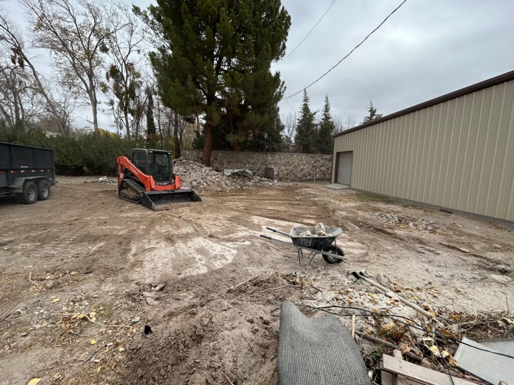 A construction site with debris and a skid steer, indicating a junk removal job by Easy Load Disposal El Paso in El Paso, TX.