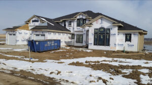 An ASAP Containers inc. blue dumpster at a residential construction site for debris removal in Omaha, NE.