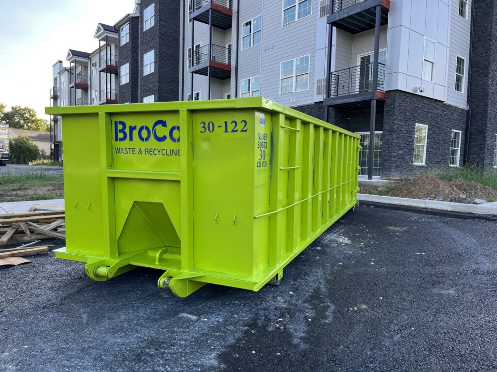 A green Broco Waste & Recycling dumpster at a construction site in Warminster, PA.