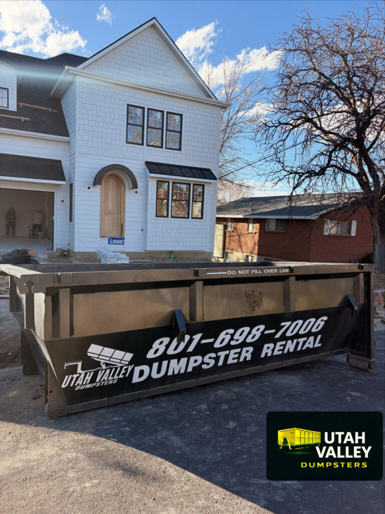 A black dumpster from Utah Valley Dumpsters placed at a construction site in Provo, UT.