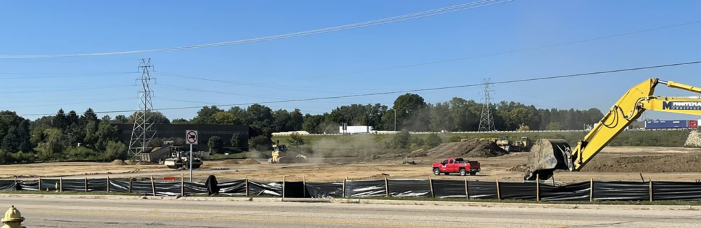 A large construction site with earthmoving equipment and a red pickup truck by R A Seaton Contractor Services in Rockford, IL.