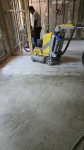 Industrial vacuum and equipment on a concrete floor at a construction site, showing floor preparation by Cornerstone Services Management in Miami, FL.
