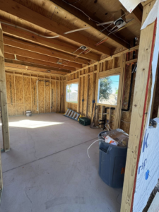 An interior construction site with wooden framing, electrical, and plumbing rough-ins by CK Customs LLC in Surprise, AZ.