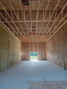 Long view of a construction site interior with wood framing and insulation installed by Prairie Insulation LLC in Springfield, IL.