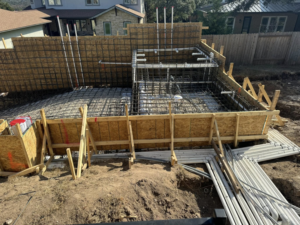 A construction site showing pool excavation, formwork, and pipes laid out by Stealth Civil Contracting in Austin, TX.
