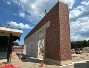 A construction site showing the installation of a precast concrete and brick wall by Lombard Architectural Precast Products Company in Aurora, IL.