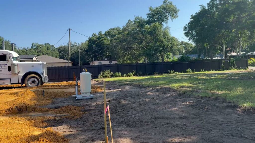 A construction site undergoing preparation with a truck and propane tank by Beyond Builders in Tampa, FL