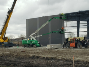 Construction site with workers installing exterior panels on a new building by Integrated Building Systems, Inc. in Westmont, IL.