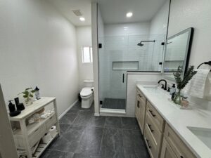 Contemporary bathroom remodel with a spacious walk-in shower and dual vanity by APJ Construction Inc. in El Paso, TX.