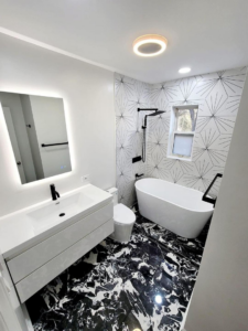 A contemporary bathroom renovation with a sleek freestanding tub and patterned floor tiles by Dr.House in Orlando, FL