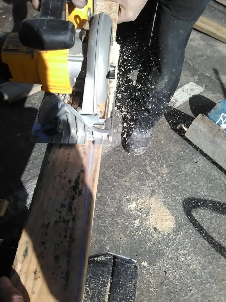 A contractor cutting a piece of wood with a circular saw for a project by Red Gator Maintenance in Fresno, CA.