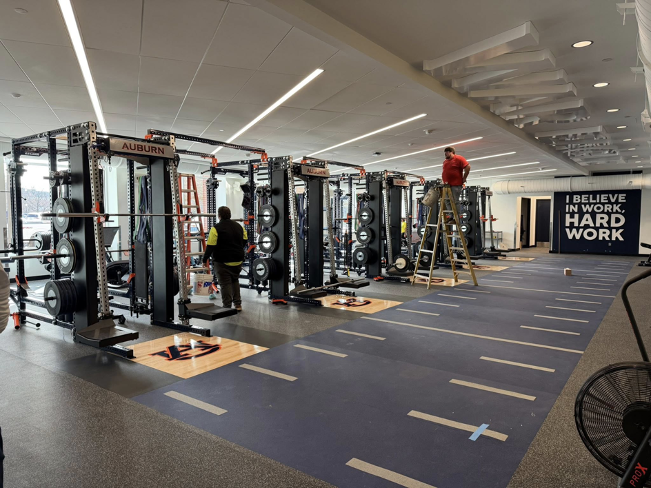 A contractor on a ladder performing ceiling work in a fitness facility by Jack Ellison Painting Contractors Inc. in Montgomery, AL.