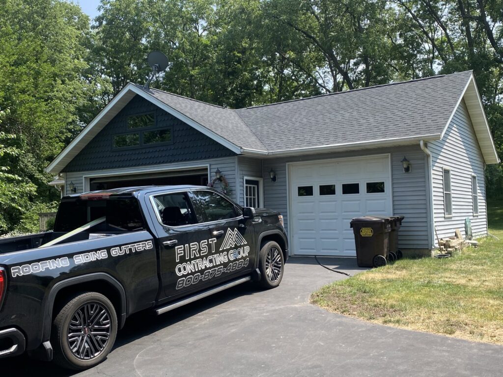 A First Contracting Group truck parked in front of a newly completed roofing project in Rockford, IL.