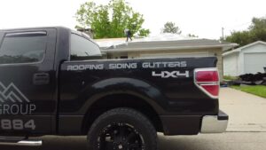 A First Contracting Group truck parked outside a home where workers are installing a new roof in Rockford, IL.