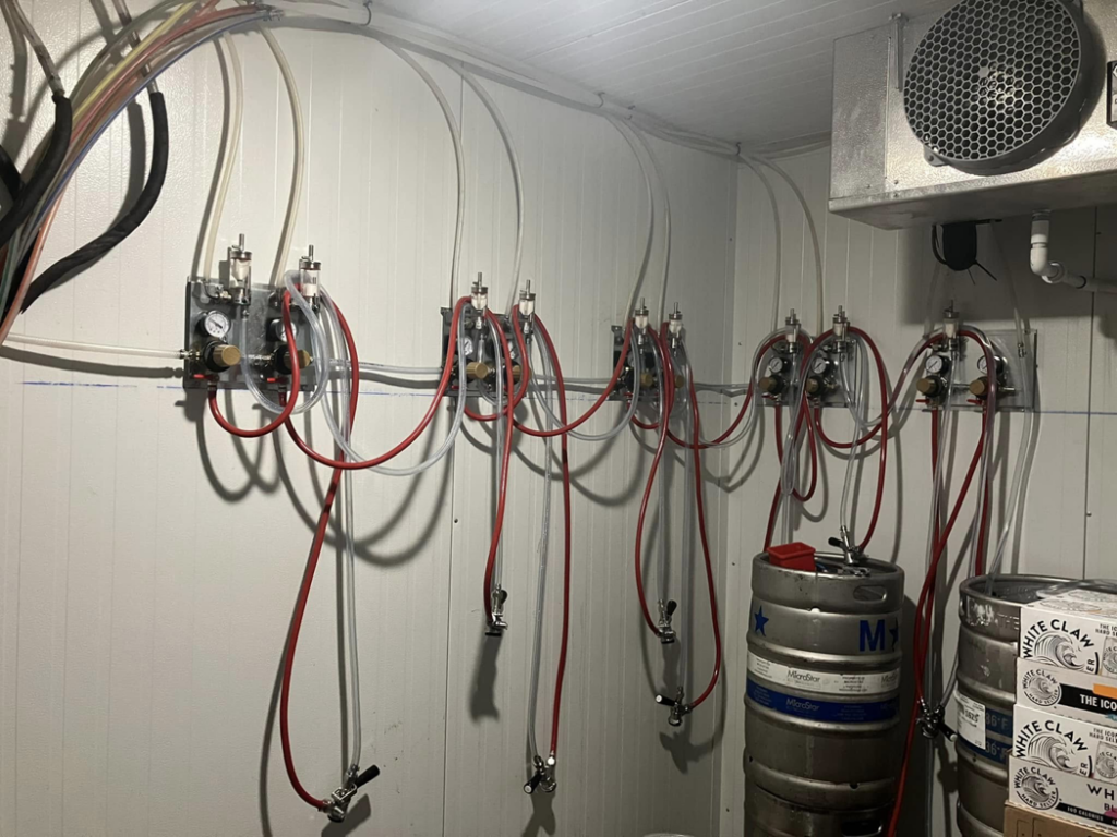 Beverage lines and connections installed in a cooler, ready for kegs, by Black Tide Beverage in Lakewood, CO.