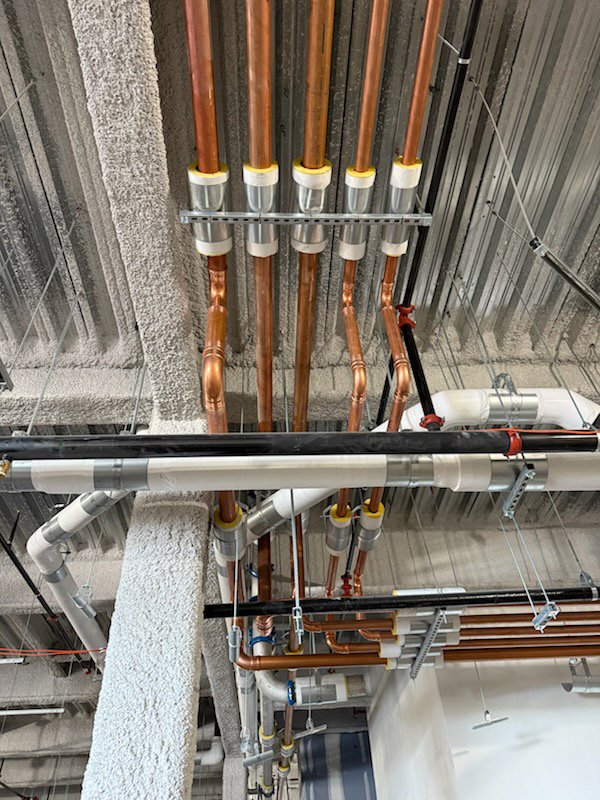 Detailed installation of copper and PVC pipes along a ceiling by Gorman-Lavelle Corp in Cleveland, OH