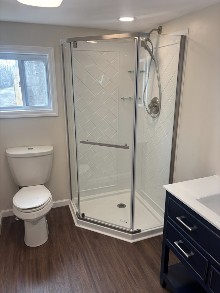 A newly installed corner shower and toilet in a bathroom by Fox Renovations in Knoxville, TN