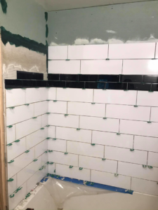 Corner of a bathroom shower area with white and black subway tiles being installed by Ken Sweeney Property Solutions in Knoxville, TN