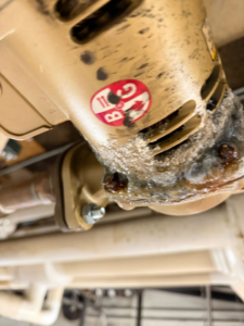 A close-up of a corroded pipe connection needing repair by Comfort Mechanical Heating and Cooling in Ann Arbor, MI.