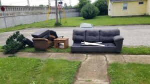A couch, armchair, and side table placed curbside for junk removal by Indy Trash Guy in Fishers, IN.