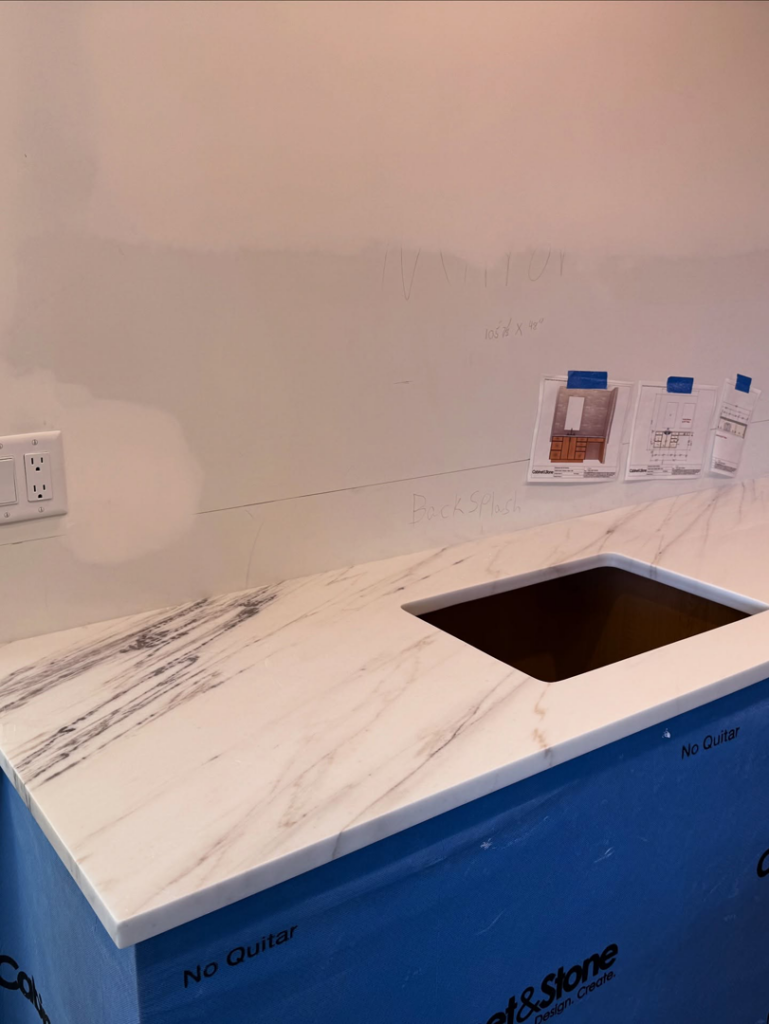 A new countertop with a sink cutout, covered in protective material, during installation by Arcadia Building Company in Mesa, AZ.