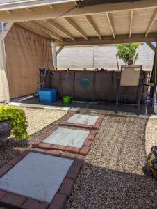 A backyard with a covered patio structure, above-ground pool, and stepping stones by Centennial Builders, LLC in Litchfield Park, AZ.