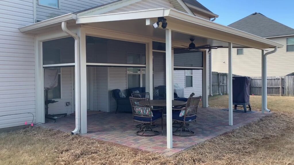 A covered patio with a screen enclosure and outdoor furniture by Four Seasons of River City in Columbus, GA.
