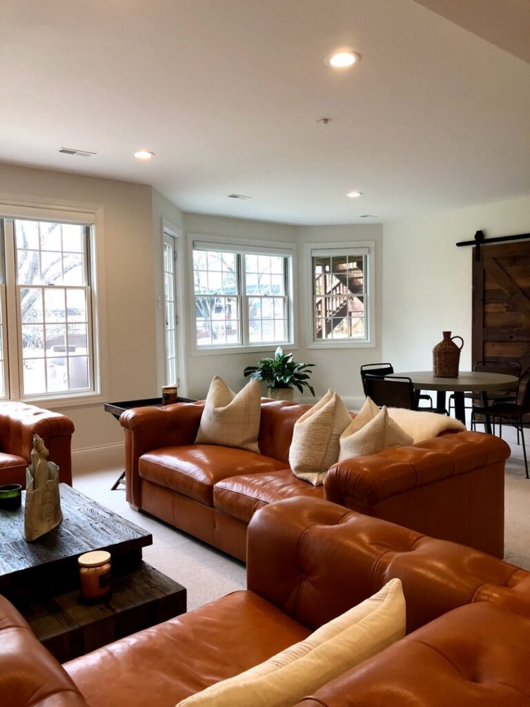 A cozy living room featuring leather sofas and a rustic barn door, completed by Creasey Construction of Illinois, Inc. in Springfield, IL