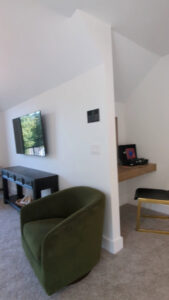 A cozy reading nook with a green armchair and a built-in desk in a modern home by DJK Custom Homes in Naperville, IL