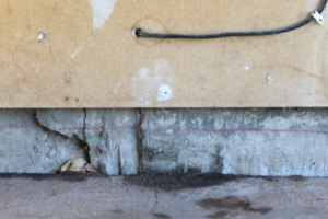 Severe cracks and damage visible in a concrete foundation or wall, requiring expert repair from American Mud Jack INC in Arvada, CO.