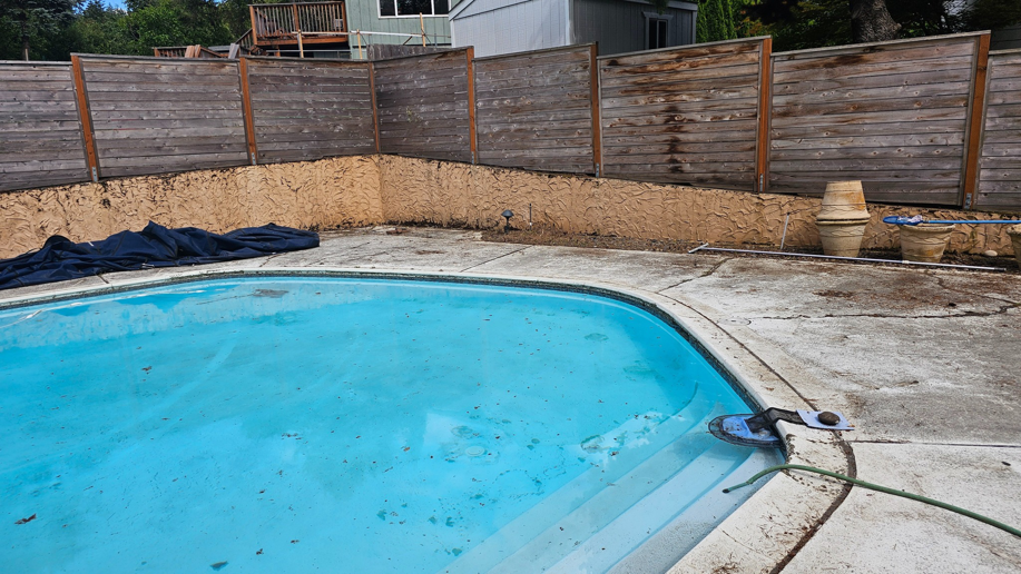 A cracked and dirty pool deck before repair and cleaning services by Done Right Handy in Wilmington, DE.