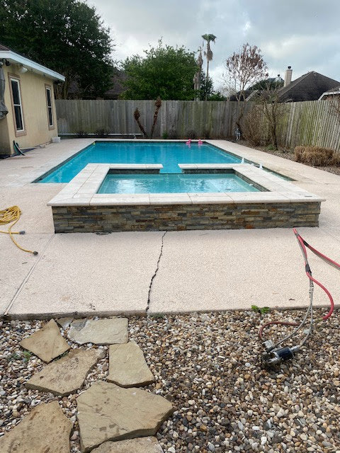 Cracked concrete patio around a swimming pool requiring repair by Complete Foundation Repairs in Corpus Christi, TX.