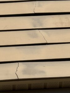 Close-up view of cracked siding on a house, indicating needed repair from Music City Exteriors in Nashville, TN