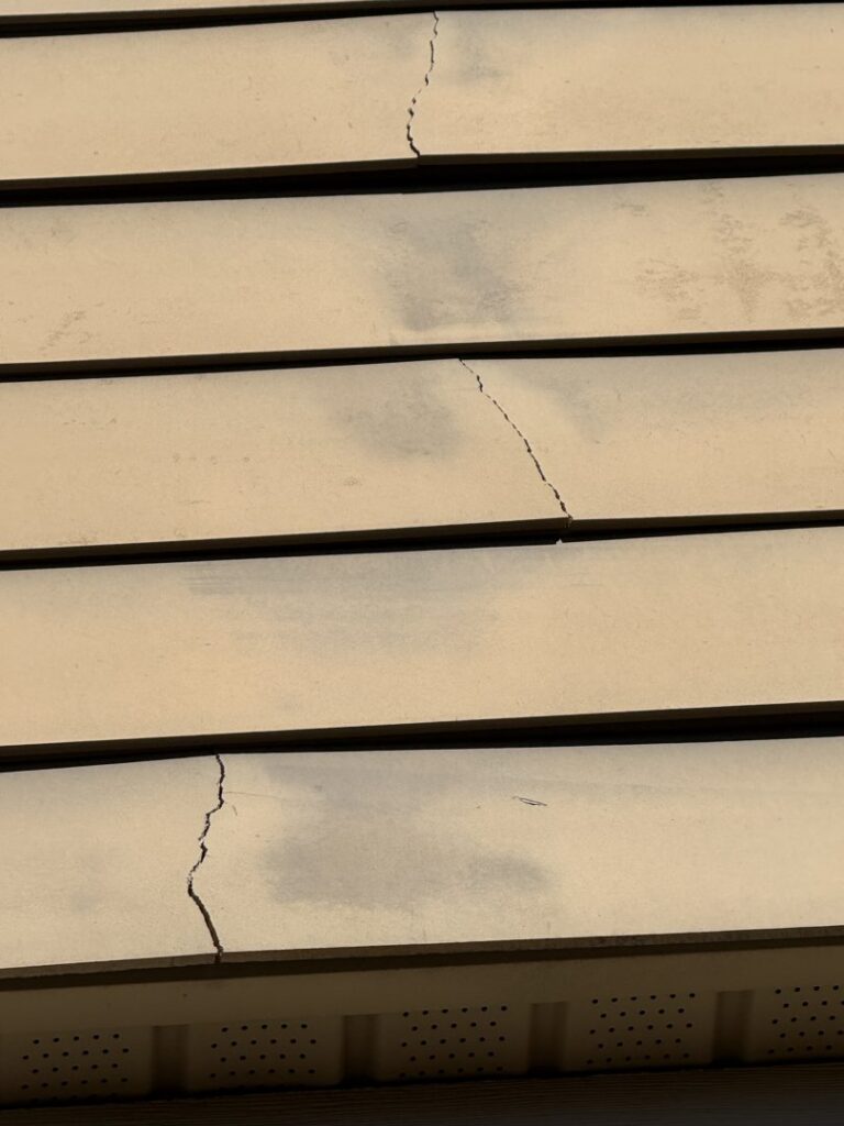 Close-up view of cracked siding on a house, indicating needed repair from Music City Exteriors in Nashville, TN