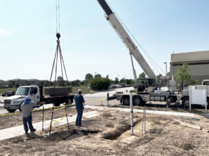 A crane lifting a large concrete block into place on a construction site by Arco Concrete Inc in Fort Lupton, CO