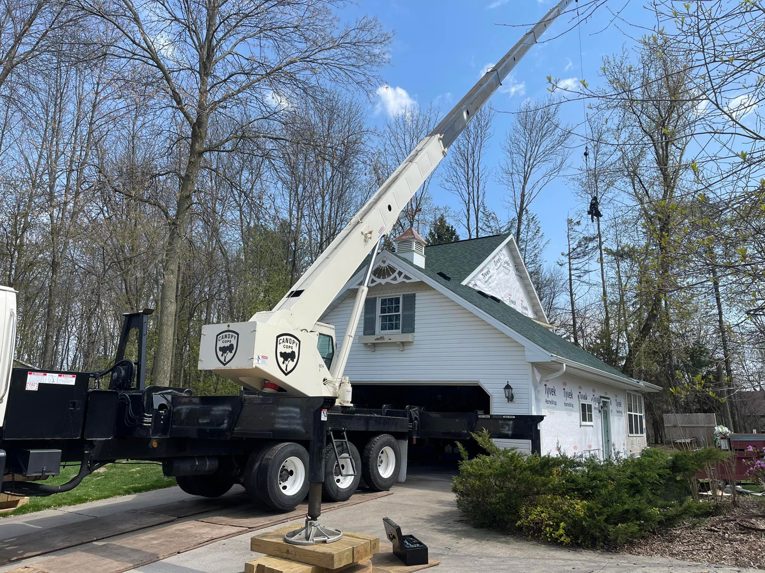 A large crane truck from Canopy Cops Tree Service LLC is set up at a residential property for tree removal in Appleton, WI.
