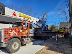 A branded crane truck from Lumberjacks Tree Service parked on a residential driveway during a tree service job in Chattanooga, TN.