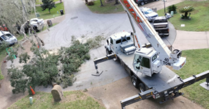 An aerial view of a crane truck set up for a tree removal operation by Herrick's Tree Service in Jacksonville, FL.