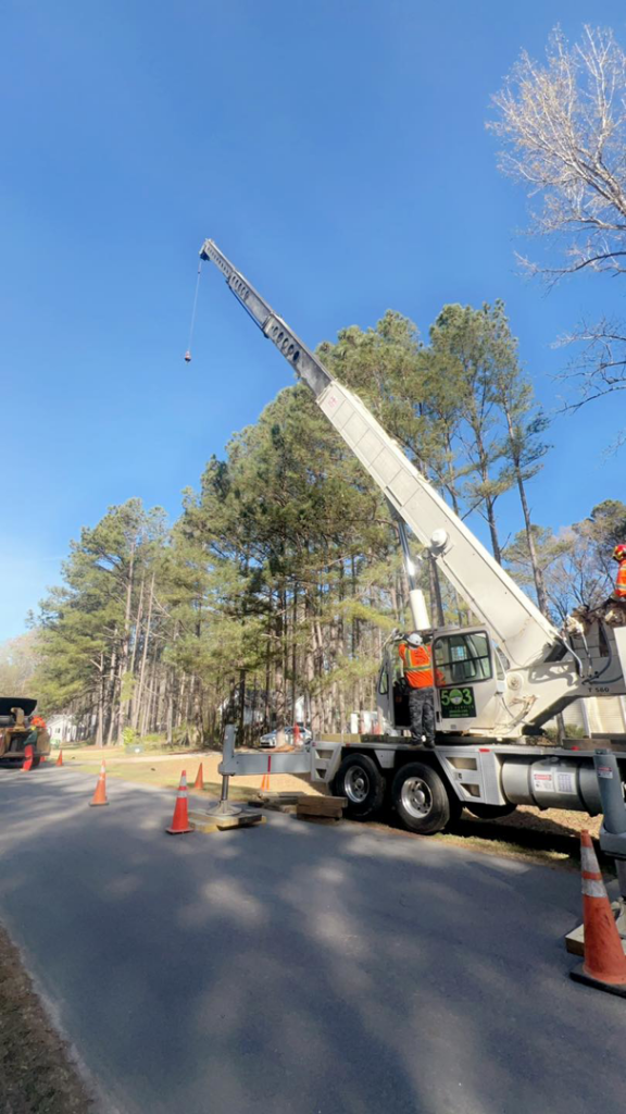 A large crane truck with a worker in safety gear performing tree removal services for 503 Tree Service NC LLC in Cary, NC.