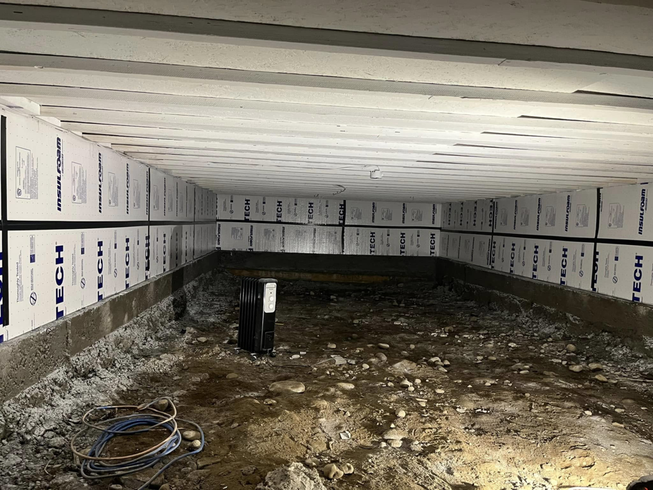 Crawl space insulation installation in progress, a service provided by Worths handyman services in Wasilla, AK.