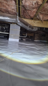 A clean crawl space with new white vapor barrier, insulation, and ductwork installed by My Creepy Crawlers, inc in Concord, NC.