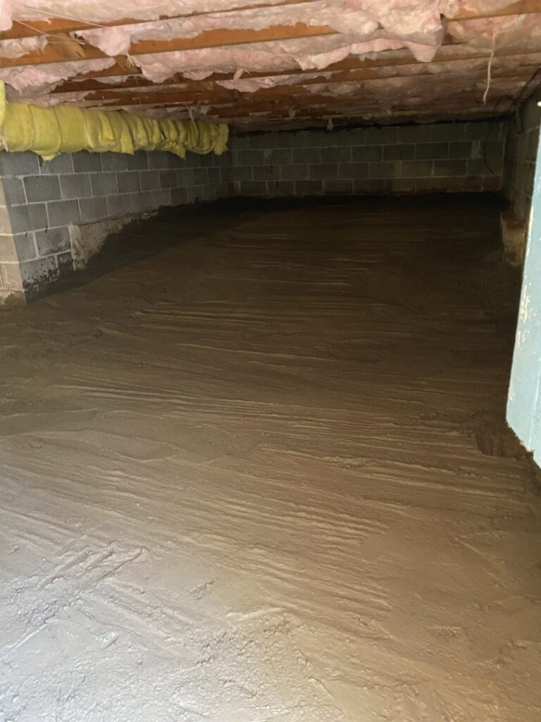 A clean crawl space with a newly sealed or concrete floor and cinder block walls, showcasing encapsulation work by Northwest Crawl Space Services in Kent, WA.
