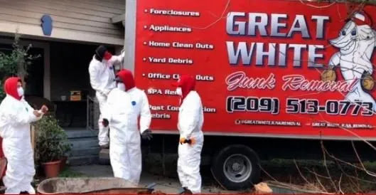 A crew in hazmat suits standing next to a Great White Junk Removal truck during a cleanout job in San Francisco, CA.