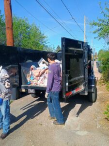 A crew loading various items into a dump trailer during a junk removal job by T-Rex Service LLC in Cheyenne, WY.