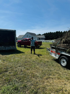 A crew member loading yard debris into a trailer for junk removal by DJ's Hauling & Junk Removal Services in Georgetown, DE.