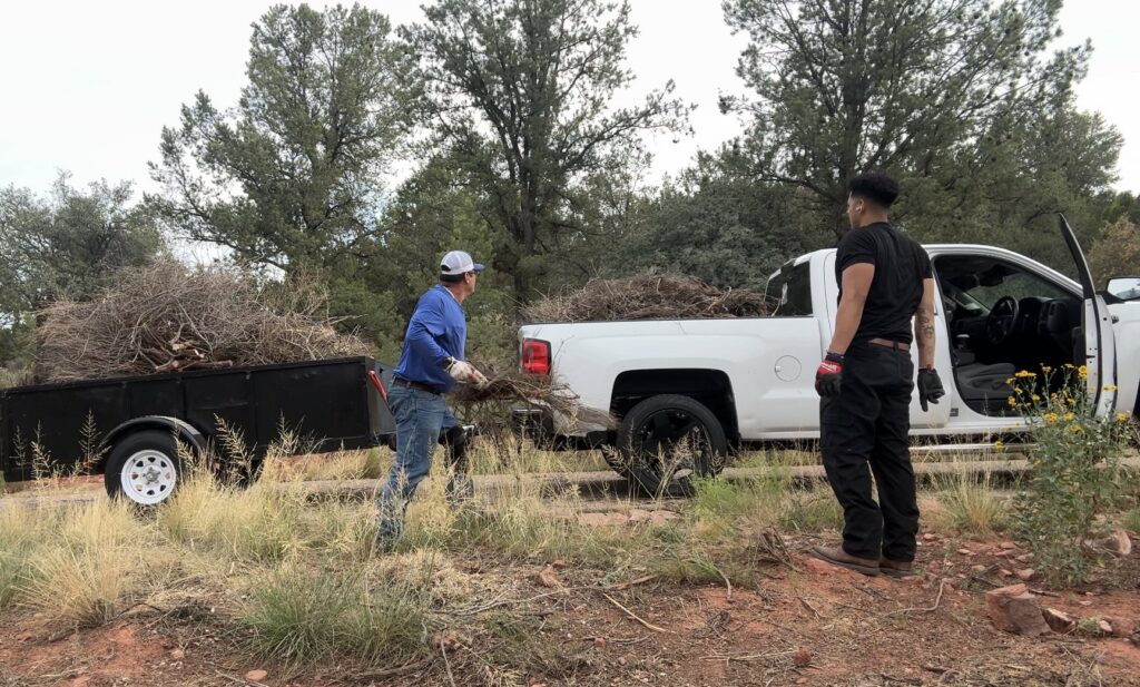 richartehelps crew members loading yard waste and brush into a utility trailer for removal in Scottsdale, AZ.