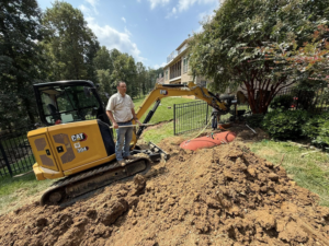 A crew member supervising the removal of an underground tank with an excavator by West Way Landwork in New Market, AL.