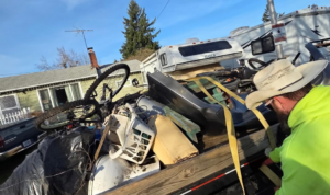 A Squirrel Squad LLC crew member securing a load of various junk on a trailer in Portland, OR.